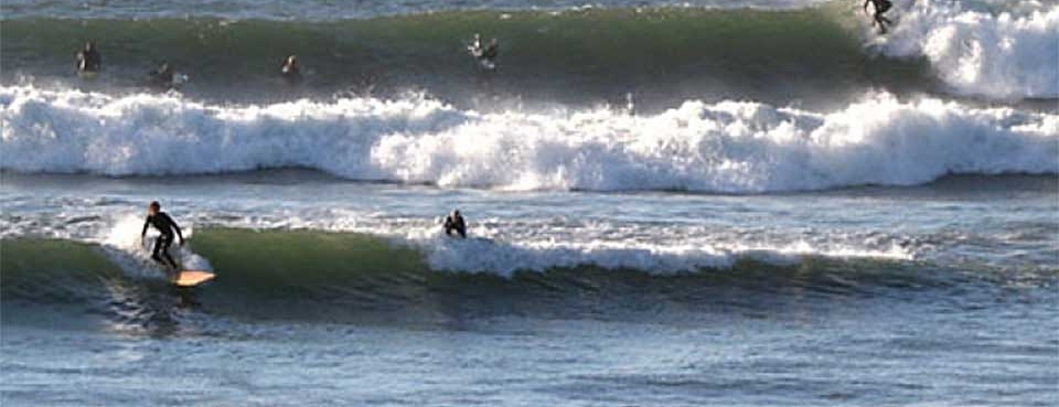 Surfers riding waves at Campus Point